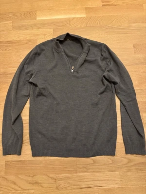 Grön half zip tröja från Stenströms - Snygg grå långärmad tröja från Stenströms med half zip och ribbad krage. Tillverkad i mjuk ull som känns skön mot huden. Perfekt för dig som gillar stilrena och klassiska plagg med en modern twist.