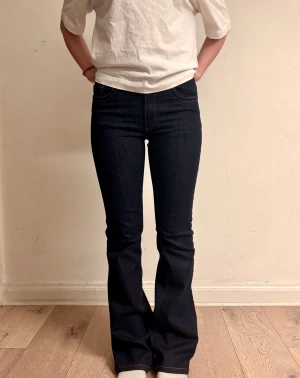 Mörkblå bootcut jeans  - Innerbenslängd: 82cm                                   Midjemått rakt över: 35 cm                        Grenlängd: 22 cm                                       Benöppning: 24 cm 