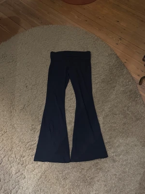 Mörkblåa yogapants  - Säljer ett par blåa yogapants med låg midja. De har en mjuk och passform som sitter snyggt över höfterna och låren, och släpper ut vid benen. Så sköna och snygga! Köpta i Italien och går inte att köpa längre💙
