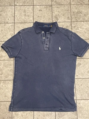 Blå Polo Ralph Lauren piké - Skick: 8/10 | Urtvättad färg| Storlek: XS | Mitt pris: 500 | Pris kan diskuteras vid snabb affär! | Hör av er vid frågor eller funderingar ëd