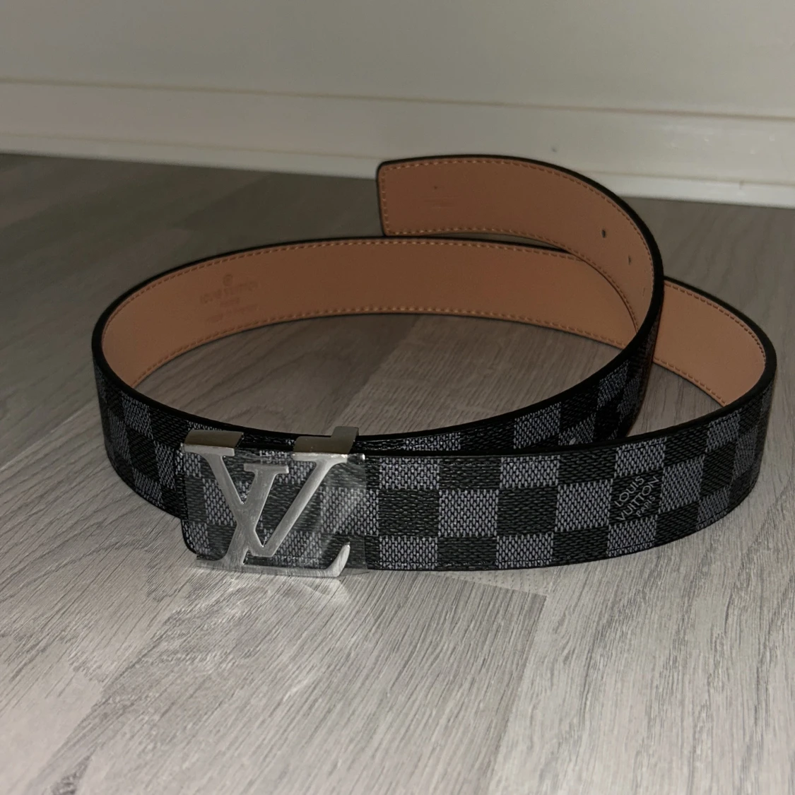 Ett svart bälte med silver logga från Lindex - 1