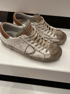 Philippe Model  - Säljer ett par slitna philippe model skor med vita och bruna detaljer! 