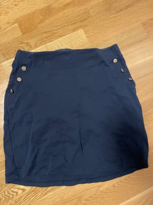 marinblå kjol - marinblå kjol med guldiga detaljknappar från vero moda! OBS: matchande kavaj finns som separat inlägg