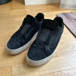 Arigato skor - Säljer nu mina svarta mocka Axel Arigato skor i fint skick. Skorna har tecken på användning men är väl omhändertagna. De är i storlek 42 och sitter bra i storleken. Inget og tillkommer men det tillkommer en annan sko box. Nypris 2600kr. Vid frågor eller funderingar är det bara att höra av sig😊.