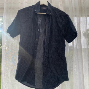 Mörkblå kortärmad skjorta Brothers - Snygg mörkblå skjorta från Brothers med korta ärmar och diskret småmönster.