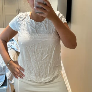 Vit t-shirt från ONLY, strl 38 - En enkel och fräsch vit t-shirt från ONLY i storlek 38. Modellen har rund hals och korta ärmar, perfekt för en clean och chill look. Materialet är mjuk bomull som känns skönt mot huden. Passformen är normal och t-shirten är lätt att matcha med allt. Den behövs bara strykas