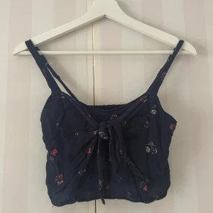Topp Hollister - Söt croppad topp med blommor och gullig knytdetalj fram🫶🏻