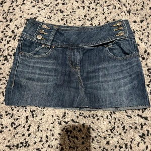 Jeanskjol från Karen Millen Denim - SkitSnygg jeanskjol från Karen Millen Denim i klassisk blå tvätt. Kjolen är kort med rå kant nertill, har coola detaljer med knappar i midjan och fickor både fram och bak. Pris kan absolut diskuteras💖
