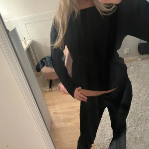 Svart stickad tröja från VILA - En svart stickad tröja från VILA med lång ärm och enkel, rak passform. Den har ett hål längst ner vid ena armen men de är bara att sy, sen har de varit ett hål på framsidan som jag har sytt, (se bild 3) materialet är väldigt mjukt och skönt på tröjan iallafall 