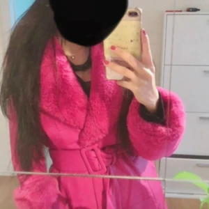 Rosa pälsjacka från Bershka med bälte - Säljer en lång, fluffig rosa pälsjacka från Bershka. Jackan har bred krage, stora ärmslut och matchande bälte i midjan. Perfekt statement-plagg för dig som vill sticka ut med färg och stil. Jackan är helrosa och har en riktigt mjuk känsla.