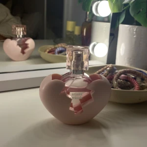 Ariana Grande parfym rosa hjärta - Superfin parfym från Ariana Grande i en unik flaska formad som ett trasigt rosa hjärta. Flaskan är genomskinlig med rosa detaljer. Perfekt för dig som gillar snygg design och söta dofter💞💞💞💞