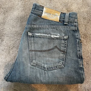 Blå jeans från Jacob Cohën - Skick: 9/10, sköna slitningar som inte påverkar passformen - Storlek: 33 - Längd:101cm Midja:42cm ben:16,5 - Nypris: 5000 kr+