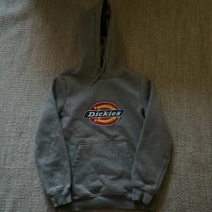 Grå Dickies hoodie med logga XS - Säljer en grå hoodie från Dickies i storlek XS som oxå passar S. Den är i jättebra skick, använd max 3 gånger. Säljer för det inte är min stil. 
