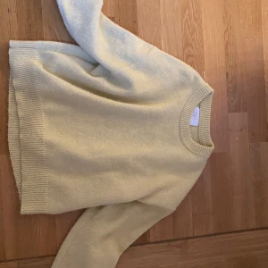 Ljusgul stickad tröja från Zara - Mysig ljusgul stickad tröja från Zara i storlek 164. Tröjan har rund halsringning, ribbade muddar och är långärmad. Perfekt för dig som gillar en enkel och stilren look med en touch av färg.