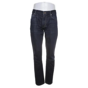 Mörkblå jeans från J.Lindeberg - Snygga mörkblå jeans från J.Lindeberg i klassisk rak modell. Jeansen har fem fickor, kontrastsömmar och är tillverkade i slitstarkt bomullsjeans. Perfekta för dig som gillar stilrena och tidlösa byxor.