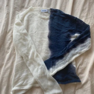 Vit och blå stickad tröja Weekday - Säljer en stickad tröja från Weekday i storlek S. Tröjan har en cool tvåfärgad design med ena sidan vit och andra sidan mörkblå. Långärmad och tunn i materialet, perfekt för lager på lager. Passar dig som gillar unika plagg!