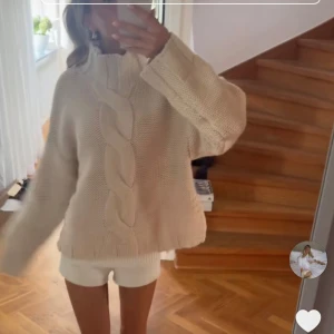 Beige stickad tröja från Zara - Supermysig beige stickad tröja från Zara med grov flätstickning framtill och hög krage. Tröjan har en loose passform och långa ärmar, perfekt för kyliga dagar. Enkel att styla med jeans eller kjol för en chill look. Helt slutsåld💗Endast testad