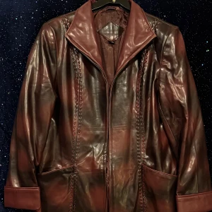 Aosimani rödbrun jacka, storlek M-L 42-44 - Elegant lång skinnjacka i en unik rödbrun nyans med dekorativa detaljer längs framsidan. Jackan har en klassisk krage och stängs med dragkedja. Perfekt för att addera en sofistikerad touch till din outfit.  OBS: Jackan är märkt större men motsvarar inte XXXL enligt måtten.  Storlek & mått (ca): 	•	Byst: 53 cm (106 cm runt om) 	•	Ärmlängd: 60 cm 	•	Ärmbredd upptill: 18 cm 	•	Längd: 101 cm  Motsvarar ungefär damstorlek 42–44 (M/L). Detta är en längre modell (skinnrock).