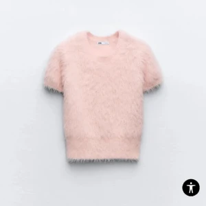 Ljusrosa fluffig stickad tröja Zara - Supermjuk och fluffig ljusrosa stickad tröja från Zara med korta ärmar och rund hals. Tröjan har en mysig känsla och är perfekt för dig som gillar en söt och trendig look. Passar snyggt till både jeans och kjol.