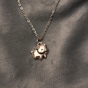 Halsband gris silver imitation  -  10 % av detta köp skänker jag till Malvadal Grisfristad.  Så gulligt halsband med en liten berlock av en gris. Berlocken är ca 1,3 x 0,8 cm. Halsbandet är i silverimitation och justerbart 40-45 cm. 