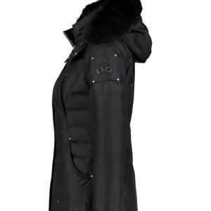  Moose Knuckles w cloud parka  - Snygg svart dunjacka från Moose Knuckles med avtagbar pälskrage och dragkedja framtill. Jackan har långa ärmar, flera fickor och ikonisk logga på ärmen. Perfekt för kalla vinterdagar och ger en clean, urban look.