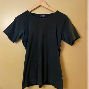 Svart t-shirt från Clique - En stilren svart t-shirt från Clique med klassisk rund hals och korta ärmar. T-shirten är i mjuk bomull och har en normal passform. Perfekt basplagg att matcha med allt. Diskret etikett i nederkant.