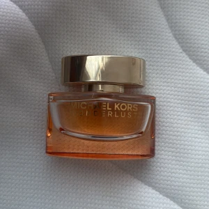 Michael Kors Wonderlust parfym - 30ml Michael Kors parfym med circa 18ml kvar. Wonderlust är en varm och inbjudande blandning med mjuka, krämiga inslag som kan ge en känsla av “dessertig värme” vid rätt förutsättningar. Den öppnar med en mjukt nötaktig sötma (mandelmjölk) som möts av citrus (bergamott) och en kryddig pepprighet (rosa peppar). 🤍