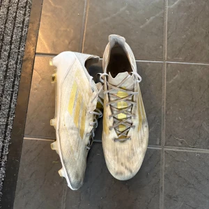 Adidas f50  - Tja säljer nu mina vit guldiga adidas f50 fotbollsskor! Sjukt snygga och slutsålda! Fint skick men använda mycket och lite svarta och så från konstgräset. Köpta för 3000 på unisont men säljer för 499! Sjukt bra pris! Skirv via frågor!