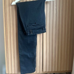 Mörkblå kostymbyxor Replay  - Snygga mörkblå kostymbyxor från Replay, modell Zeumar. Byxorna har raka ben, bälteshällor och bakfickor med knapp. Perfekta för en stilren look och tillverkade i ett mjukt bomullsmaterial med lite stretch för extra komfort.