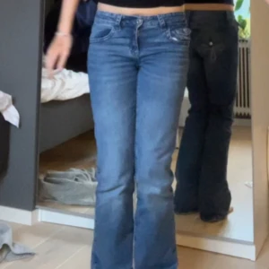 Blå bootcut jeans med broderade fickor - Säljer ett par blå bootcut jeans med snygga broderade bakfickor och låg midja. Från gina, byxorna passar mig som är i storlek S!! Har inte använt alls många gånger