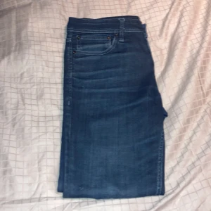 Blå jeans Jack & Jones - Snygga blå jeans från Jack & Jones, modell Tim. Jeansen har klassisk femficksdesign. Skulle säga dem passar någon mellan 175 till 180 plus någon cm som har ganska smala ben eller gillar tajta byxor. Stor storlek 32/32 men skulle snarare säg 30/32. Hör av er vid frågor!