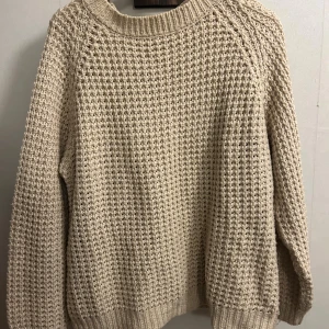 Beige stickad tröja från 157, L - Säljer en beige stickad tröja från 157 i storlek L. Tröjan har ett grovt, strukturerat stickmönster och ribbade muddar vid ärmslut och nederkant. Perfekt för lager-på-lager och chill höst- eller vinterstil.