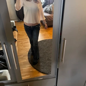 Lågmidjade bootcut jeans från true religion - Mörkblå jeans från true religion som är låg midja och bootcut. Själv är jag 176 och det passar mig i längden perfekt inte för långa eller för korta. Skriv om du är intresserad eller vill ha mer bilder på dessa