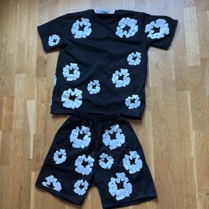 Denim tears set  -   Denim Tears med vita blommönster över hela plagget. Modellen har en loose passform och elastisk midja med snörning för extra komfort. Materialet är mjuk bomull, storleken e S men kan passa på M skriv till mig i dm om du undrar över något 