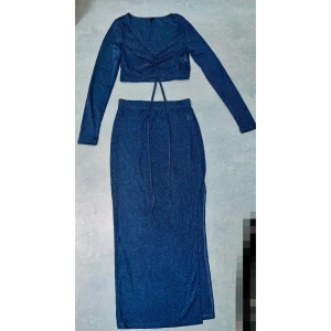 Tvådelad set blå  - Säljer ett oanvänd blått set. Stretchig och glittrigt material, passar perfekt till fest. Toppen är croppad, medan kjolen är maxi längd med slit på mig som är 164 cm. Pris kan diskuteras vid snabb affär ✨    