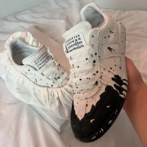 Maison Margiela GATS - Säljer nu mina as feta maison margiela gats som har svart paintsplatter. Älskar just dessa skor eftersom att de är gjorda av tyg istället för skinn, storlek 41 men passar 41-42. Hör av er vid minsta fundering!!