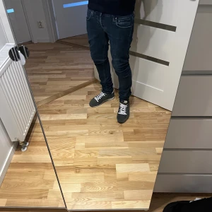 Dondup Jeans - Säljer ett par mörkblå slim jeans från Dondup med klassisk femficksdesign och snygga kontrastsömmar. Jeansen har låg midja och är tillverkade i mjukt bomullsjeansmaterial. Perfekta för dig som gillar en tight och modern passform.