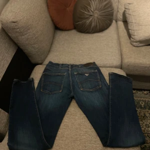 Emporio Armani blå jeans,  - Snygga blå jeans från Emporio Armani med klassisk femficksdesign och diskret logga på bakfickan. Jeansen har raka ben och normal passform, tillverkade i mjukt denimtyg som sitter skönt hela dagen. Perfekta för dig som gillar stilrena och tidlösa jeans.