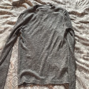 Grå ribbad tröja Saints and Mortals XS - Snygg grå långärmad tröja från Saints and Mortals i storlek XS. Tröjan är ribbad och har en enkel, klassisk design med rund hals. Perfekt för dig som gillar stilrena och bekväma plagg. Passar dig som vill ha en smalare passform.