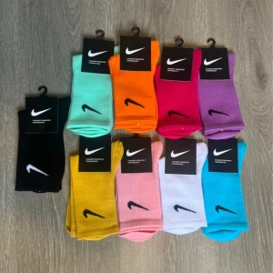 3-pack Nike strumpor. Väl fritt bland 9st färger.  - 3-pack Nike-strumpor i olika färger som svart, mintgrön, orange, ceriserosa, lila, gul, ljusrosa, vit och blå. Klassisk Nike Swoosh broderad på sidan. Perfekta för att addera färg till din outfit! Skriv önskad färg efter lagd order. 