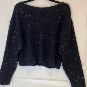 Glittrig ”kortare” tröja💫  - Tröjan är svart med silvriga paljetter på. Öppen rygg där back och har bara används en gång😇storleken är 170 men passar även om man är 160