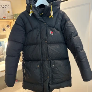 Svart Fjällräven Expedition dunjacka XS - Säljer en svart Fjällräven Expedition Series dunjacka i storlek XS. De är den modellen som är lite tjockare. Bra skick litet hål på armen. 