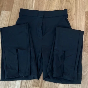 Byxor med slits  - Svarta byxor med slits framtill från nakd i stl xs.