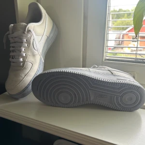 Nike Air Force 1 vita sneakers mocka - Nike Air Force 1 sneakers i vit mocka med klassisk siluett och lågt skaft.