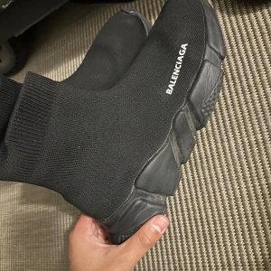 Balenciaga Speed Trainer svarta sneakers - Svarta Balenciaga Speed Trainer sneakers med stickad ovandel i syntet och chunky svart sula. Strumpliknande passform med ribbad kant och vit Balenciaga-logga på sidan. Superlätta och flexibla skor som ger en clean och modern look.