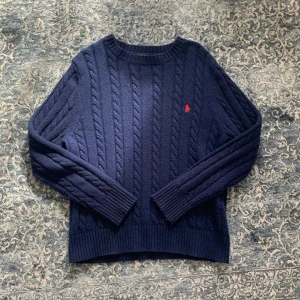 Ralph lauren tröja  - Säljer en mörkblå kabelstickad tröja från Polo Ralph Lauren. Den har tagits väl hand om och är i prima skick utan någon defekt, den är fräsch och redo för ny ägare🙌