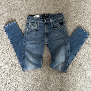 Blå Replay jeans, midwaist, 28/32 - Snygga blå jeans från Replay med klassisk femficksdesign och coola detaljer på bakfickorna. Jeansen har en rak passform och normal midja. Tillverkade i mjukt denim med en avslappnad look.