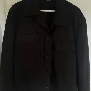Overshirt Zara - Stilren svart/brun mixad overshirt med krage och stora bröstfickor köpt på ZARA. 
