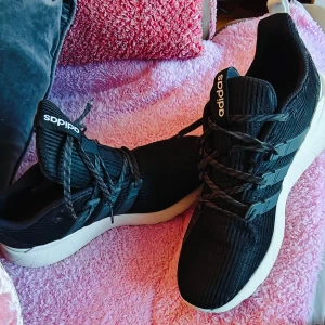 Svarta Adidas sneakers med vit sula cloud foam  - Svarta Adidas sneakers med stickad ovandel och klassiska tre ränder på sidan. Skorna har snörning och en chunky vit sula som ger en sportig vibe. Perfekta för dig som gillar streetstyle och vill ha bekväma skor till vardagen.  Viktigaste : nyskick. Och cloud foam.. känns som att gå på moln😍