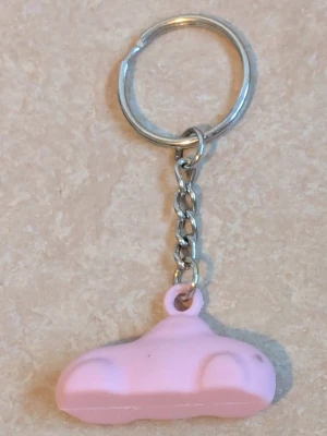 Nyckelring med rosa bil - Bilderna visar en jätte fin nyckelring med en rosa bil. Nyckelringen och den korta kedjan är av metall och den rosa bilen är av plast 